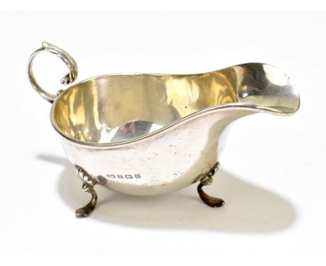 CHARLES WEALE; a George V hallmarked silver sauce boat, with scroll handle and three step supports, Birmingham 1912, length 1