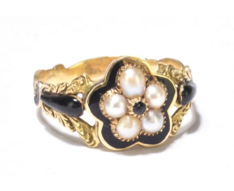 An early 19th century yellow metal and enamel mourning ring, set with a flower head formed by five seed pearls, the engraved 