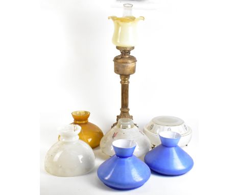 A printed metal and composition oil lamp with clear glass chimney and pale yellow crimped shade on bronzed column base, heigh