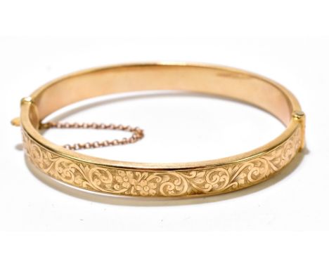 A 9ct yellow gold hinged snap bangle with engraved foliate scrolls to the upper section, external&nbsp;width 68mm, internal&n