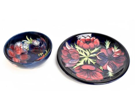 MOORCROFT; a circular plate decorated in 'Anemone' pattern on blue ground, diameter 26cm, together with a similar bowl, decor