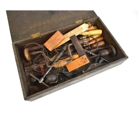 A stained pine toolbox enclosing various carpentry hand tools (quantity).