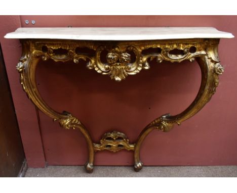 An early-mid 20th century French Louis XVI-style marble topped gilt console table of serpentine outline with scrolled detail 