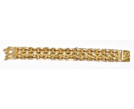 A yellow metal broad open link bracelet with engraved detail to the clasp, indistinctly marked, length 15cm, approx 25.9g.Add