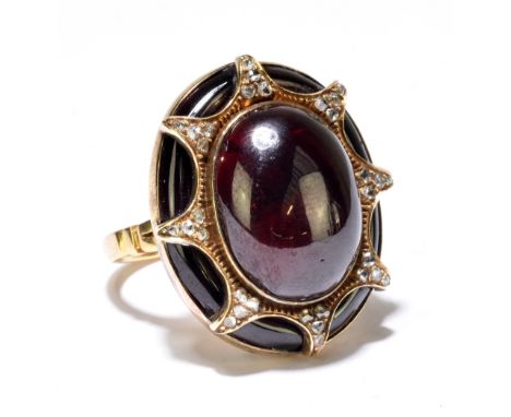 An 18ct yellow gold garnet and diamond ring, the large oval cabochon set within a framework of thirty-two tiny diamonds with 