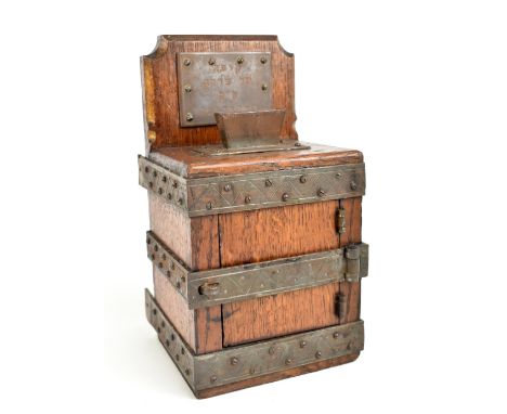 JUDAICA; a late 19th/early 20th century Tzedakah (charity) box, the oak body with iron frame and hinged door beneath a plaque