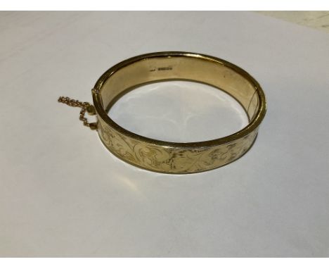 A 9ct gold hinged bangle, with engraved foliate detailing, weight approx 17g.Additional InformationSome small little dents an