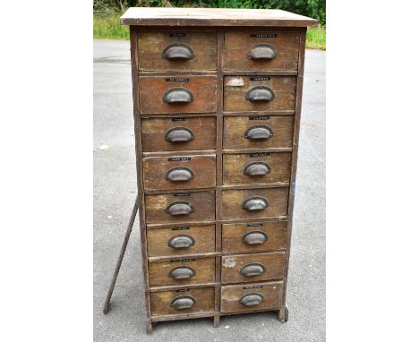 An Edwardian oak bank of sixteen short drawers, each with cusped handles, enclosing various tools and accessories, height 122