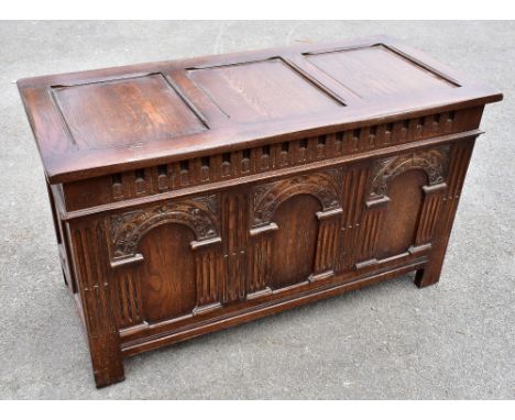 An early 20th century carved and stained oak coffer, with triple arched panelled front, on stile feet, height 60cm, width 107