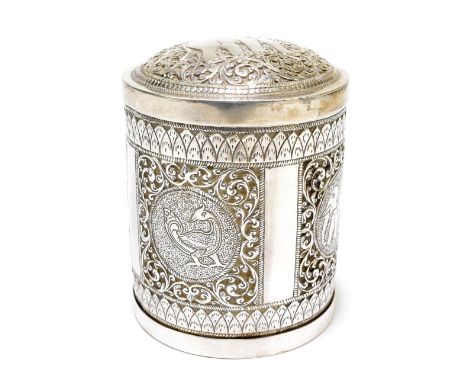 An Eastern white metal cylindrical tea canister and cover, the lift-off lid decorated with an elephant with further elephants