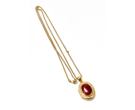 An 18ct yellow gold fine link chain suspending an 18ct oval hinged locket set with oval panel of red enamel within a border o