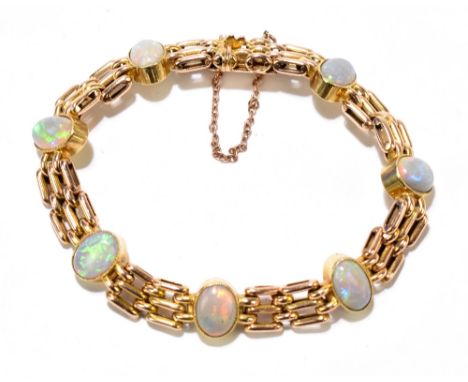 A 15ct gold opal set bracelet, the gate link bracelet set with seven oval opals, with guard chain, gross weight approx. 19.5g