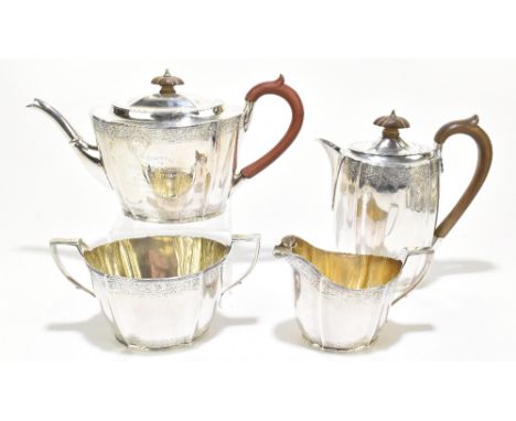 A George V hallmarked silver four piece tea set with band of engraved detail to both upper and lower sections, the teapot ins