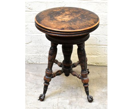 An Edwardian piano stool on ring turned central column and four stretchered splayed support to ball and claw feet.Additional 