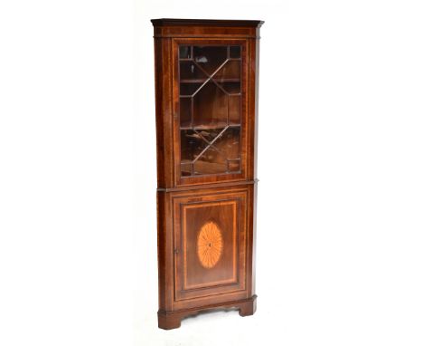 An Edwardian inlaid mahogany Sheraton revival corner cabinet, the upper section with single astragal glazed door enclosing tw