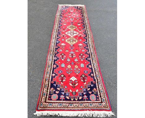 A Caucasian red ground runner, 340 x 80cm.
