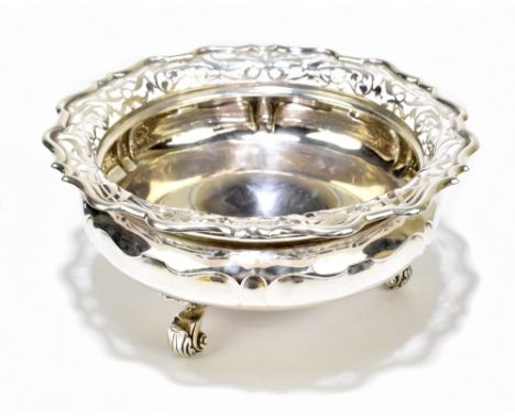 GOLDSMITHS &amp; SILVERSMITHS CO LTD; an Edwardian hallmarked silver bowl with pierced foliate scroll rim and raised on three