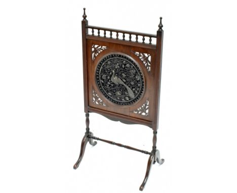A Victorian carved mahogany Aesthetic fire screen, the circular central panel inset with a metal thread and velvet panel depi