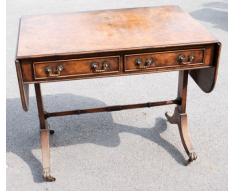 A 19th century Regency style walnut sofa table, with two drawers, on standard end supports with turned stretcher, on splayed 