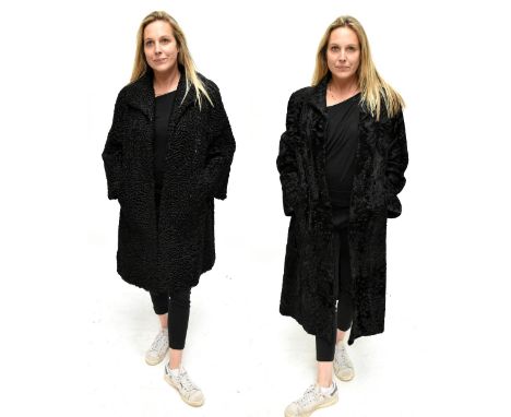 A vintage Astrakhan black curly lamb 3/4 length fur coat made by Mertons, the Furriers, Altrincham, with front fastenings and