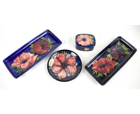 MOORCROFT; four pieces decorated in the 'Anemone' pattern comprising two rectangular pin trays, a circular pin dish, a lidded
