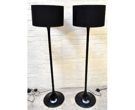 A pair of modern black standard lamps purchased at Habitat, with black shades on outswept circular bases, height 145cm.Additi