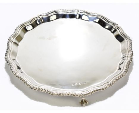 BD; an Elizabeth II hallmarked silver waiter of circular form with cast border, raised on three ball and claw feet, Sheffield