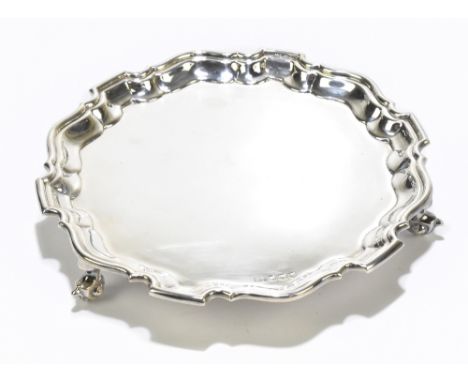 VINERS LTD; an Elizabeth II hallmarked silver waiter of circular form with scalloped edge, raised on three scrolling feet, Sh