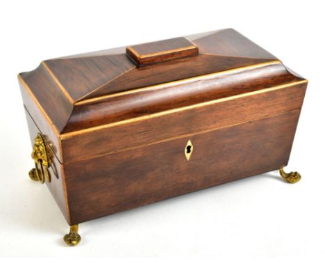 A 19th century rosewood sarcophagus form tea caddy with two canisters and blue glass mixing bowl to interior, raised on brass