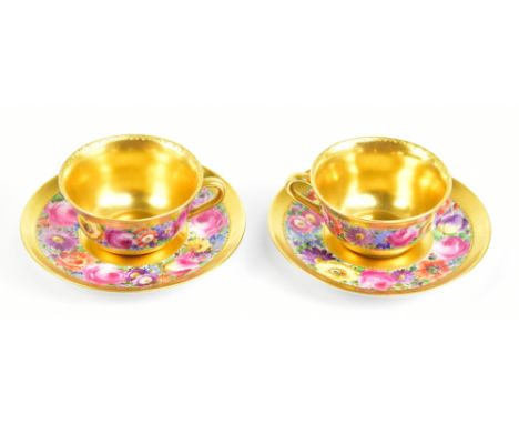 HULSCHENREUTHER; a pair of German hand painted porcelain cabinet cups and saucers decorated with flowers within gilt bands, e