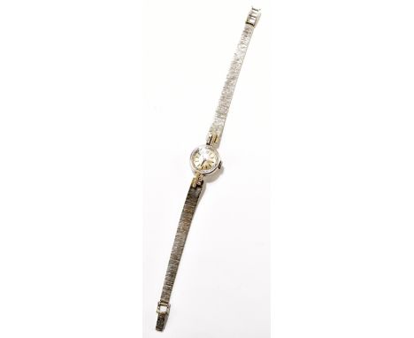 TISSOT; a lady's vintage 9ct white gold wristwatch with integral textured bracelet and set with six tiny diamonds either side