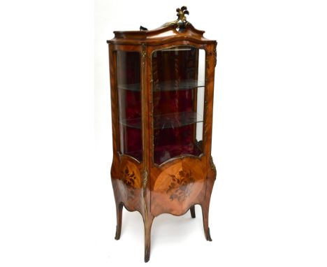 A reproduction French inspired beech and kingwood veneered vitrine of bombe outline with gilt metal mounts, floral detail and