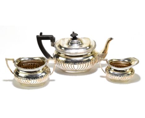 ARNOLD &amp; LEWIS; an Edward VII hallmarked silver three piece tea set with gadrooned detail, London 1909, the teapot with e