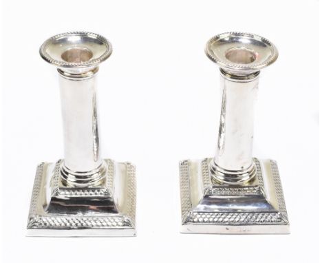 THOMAS BRADBURY &amp; SONS; a pair of late Victorian loaded hallmarked silver squat candlesticks with detachable sconces and 