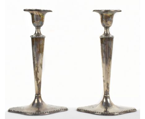 WILLIAM HUTTON &amp; SONS; a pair of Victorian hallmarked silver candlesticks of plain tapered form, on shaped loaded bases, 