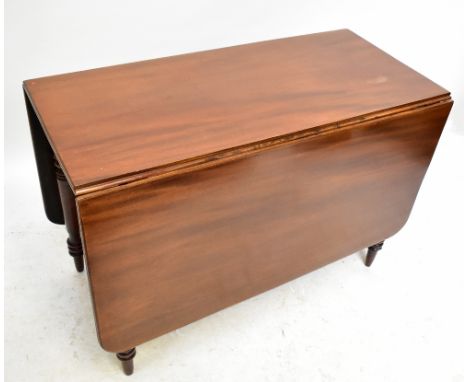 A 19th century mahogany drop leaf dining table raised on ring turned legs to peg feet.