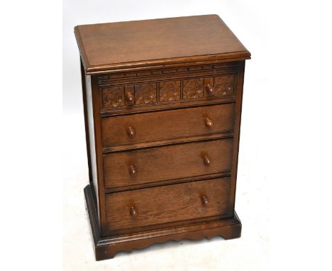 A mid-20th century oak chest of four drawers of small proportions, with carved detail to the top drawer, raised on bracket fe