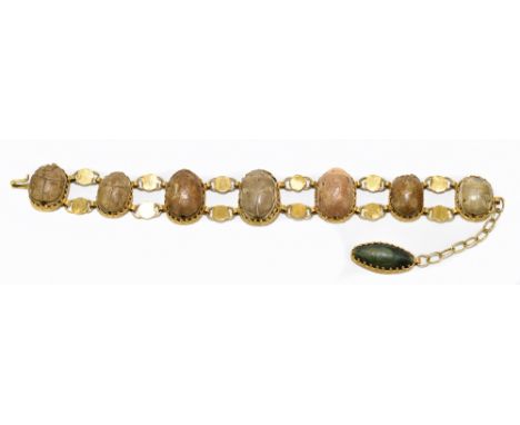 A 19th century yellow metal bracelet, set with seven Egyptian ceramic beads in the form of scarab beetles, length 22cm.Additi