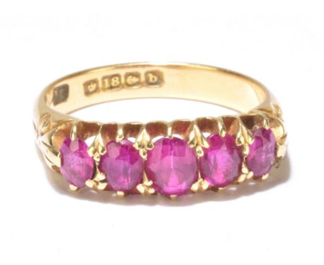 An 18ct yellow gold dress ring set with five oval cut graduated pink stones (possibly pink sapphires), size M 1/2, weight app