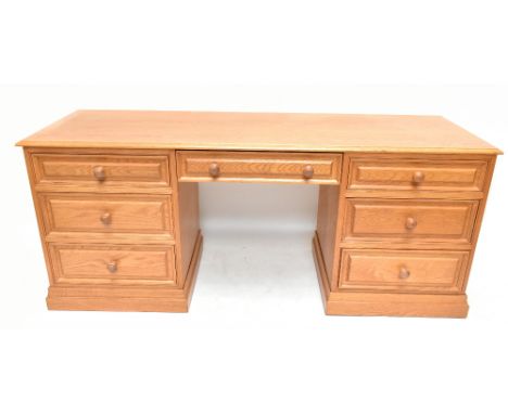 A contemporary oak veneered desk with simple top above two banks of three drawers, 72cm high, 174cm wide, 56cm deepAdditional