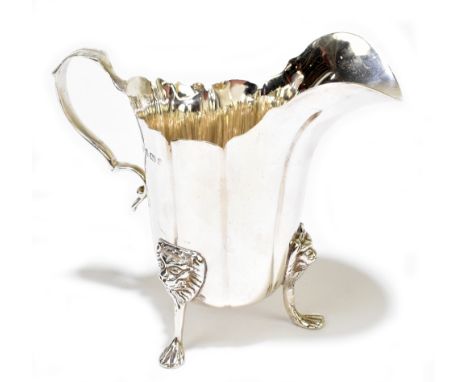 BARRACLOUGH &amp; SONS; an Edwardian hallmarked silver cream jug raised on three lion mask cap supports, Birmingham 1905, hei