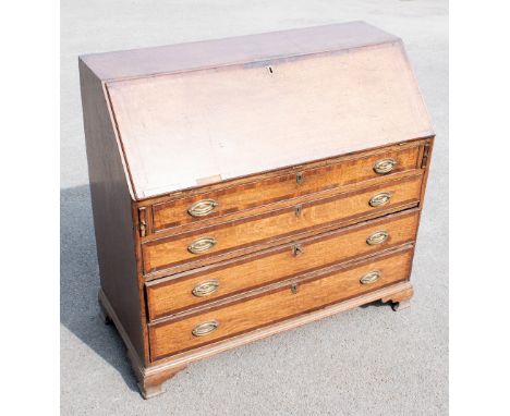 A Georgian oak bureau with fall enclosing a fitted interior, over four graduated long drawers, on ogee bracket&nbsp;feet, hei