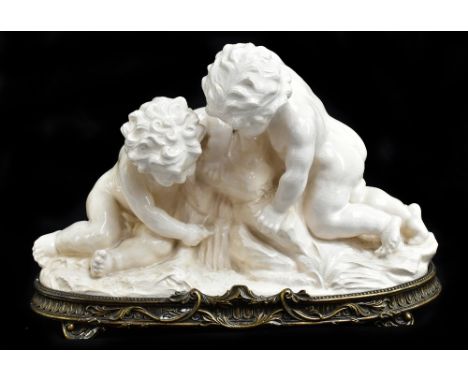 A large contemporary cream glazed figure group of two cherubs set on a gilt metal base, length 55cm.Additional InformationSom