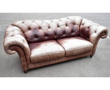 A modern Chesterfield type leather two/three seater sofa, heavily worn and stained, width 228cm.