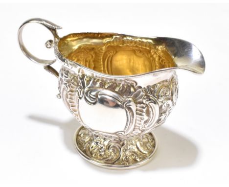 EDWARD SOUTER BARNSLEY; a late Victorian hallmarked silver cream jug with all over embossed scroll decoration and twin vacant