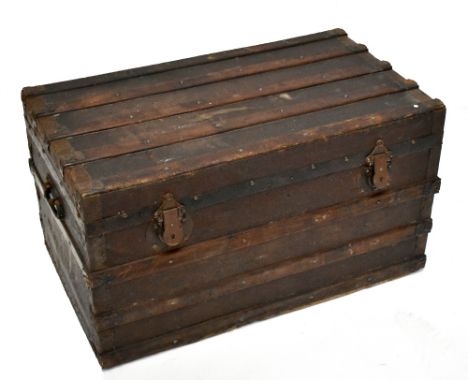 A wooden bound travelling trunk of rectangular form, the top with slatted sections, and printed initials JAD to the sides, wi