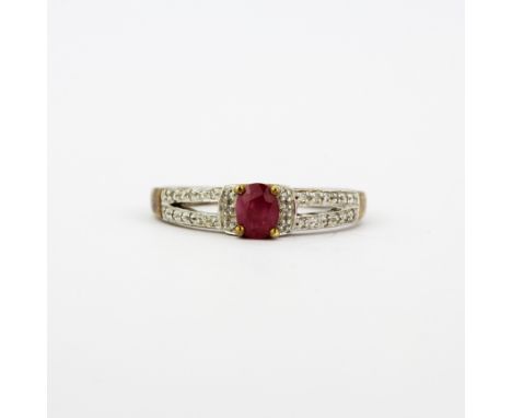 A 9ct yellow gold ring set with and oval cut ruby and diamond set shoulders, (P.5).