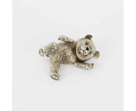 A silver (tested) teddy bear brooch set with black and white diamonds, L. 3.5cm.