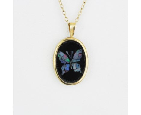 A 9ct yellow gold and onyx butterfly shaped mosaic opal pendant on a 9ct yellow gold chain, L. 50cm.