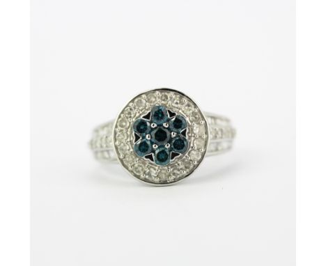 A 9ct white gold cluster ring set with fancy blue diamonds surrounded by brilliant cut diamonds and diamond set shoulders, (K